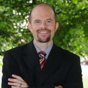 Professional headshot of Aaron Basko from the University of Lynchburg, sharing a testimonial about leadership clarity and executive coaching with Charity Medina.