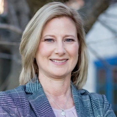 Headshot of Denise Woernle, Vice President of Communications & Marketing at Centra, smiling in professional business attire against a neutral background.