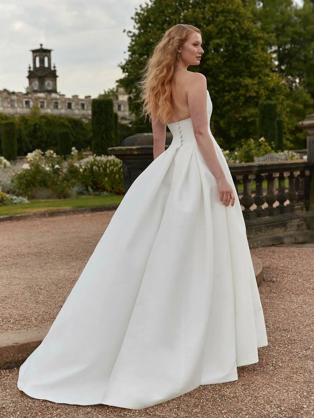 Stop scrolling for a gown that defines timeless sophistication.

The Veronica is a strapless princess-line wedding dress that effortlessly blends classic elegance with modern refinement. With box pleats cascading from the hips to create a universally