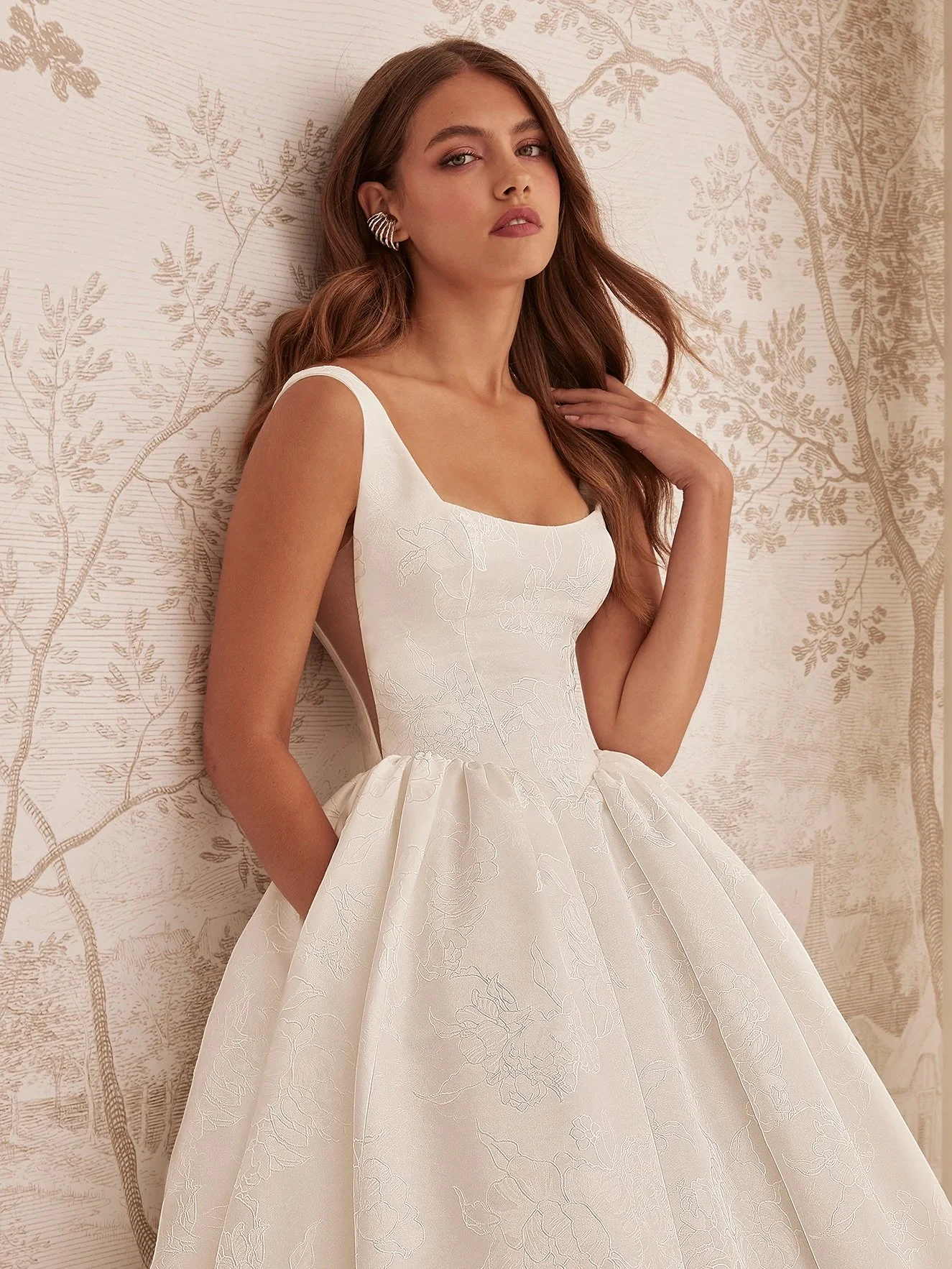 Brand new arrival alert! ✨

Meet our latest @mikaellabridal masterpiece, a breathtaking gown featuring a sleeveless Jacquard bodice with a soft square neckline and natural Italian tulle side inserts. Fabric-covered buttons trail down the back to the 