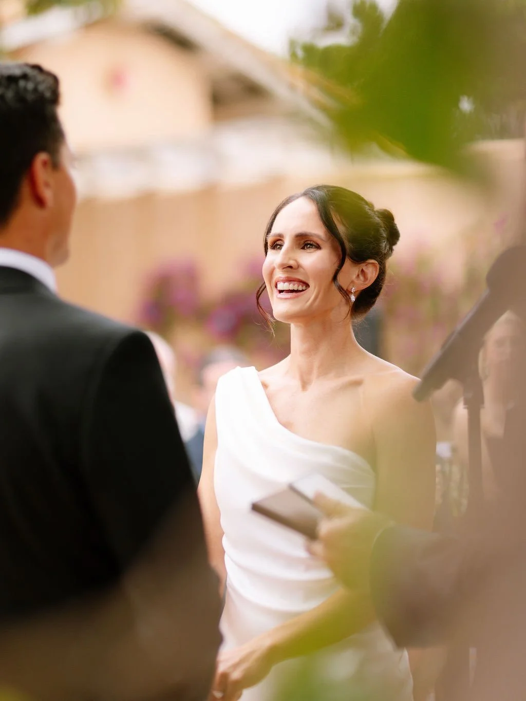 Under a canopy of olive trees and climbing ivory roses, Alli said I do in the most enchanting California garden setting. Terracotta tiles warmed by the sun, stone columns wrapped in fresh blooms, and the softest golden light filtering through the lea