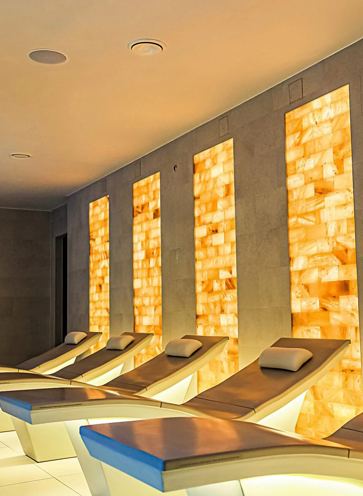 Sillas de descanso en un spa, con paredes de piedra de sal en el fondo