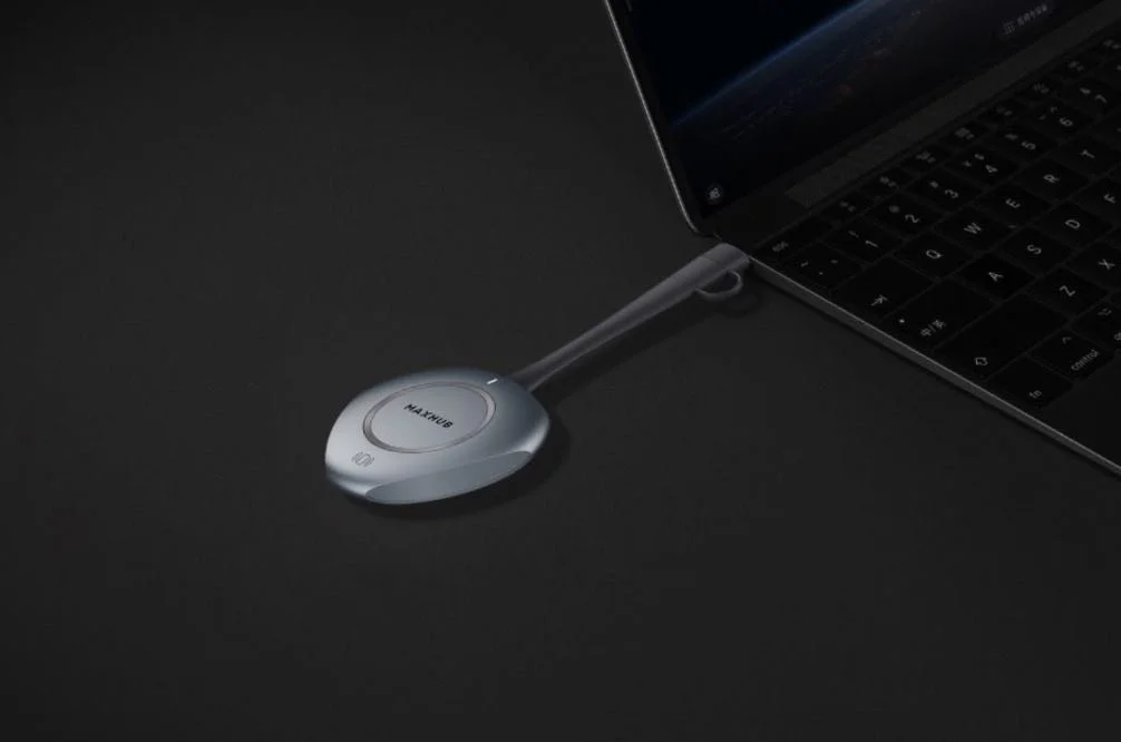 Auricular de comunicación conectado a una laptop sobre una superficie negra