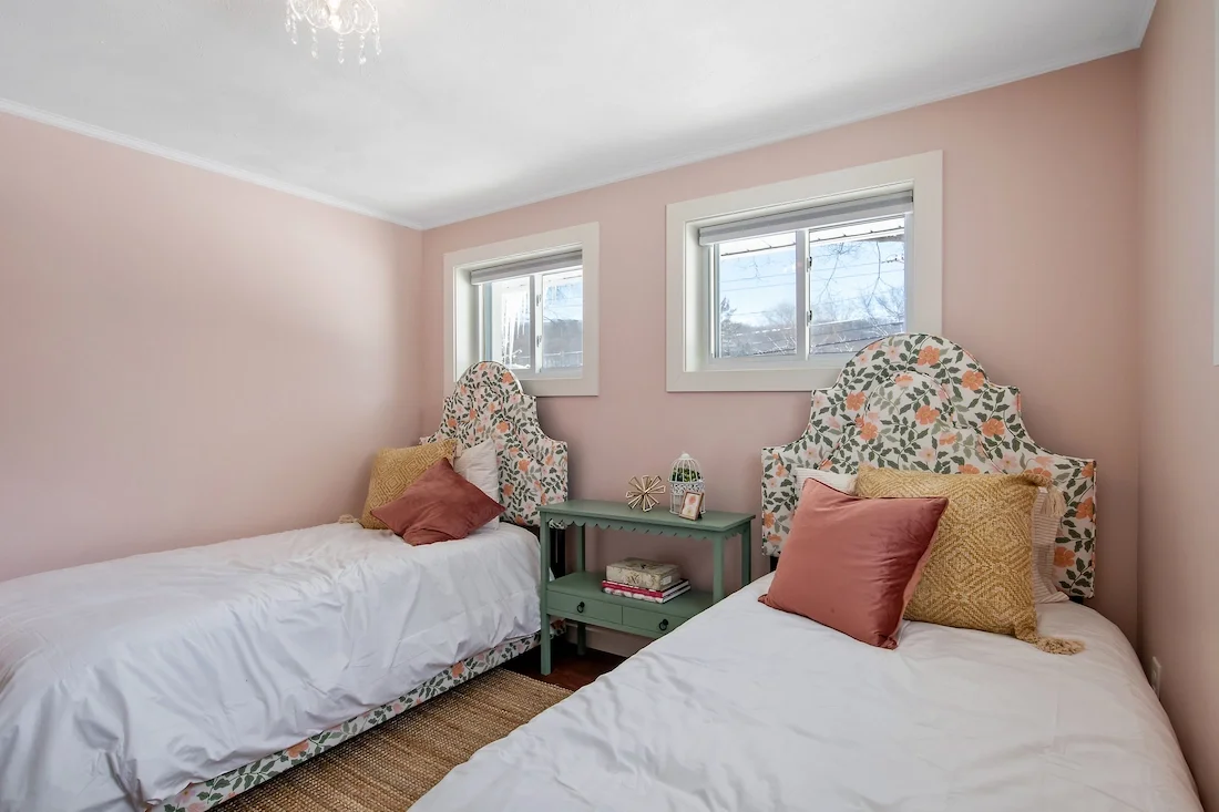 Wildflower Cottage short-term rental design pink twin beds bedroom with floral decor