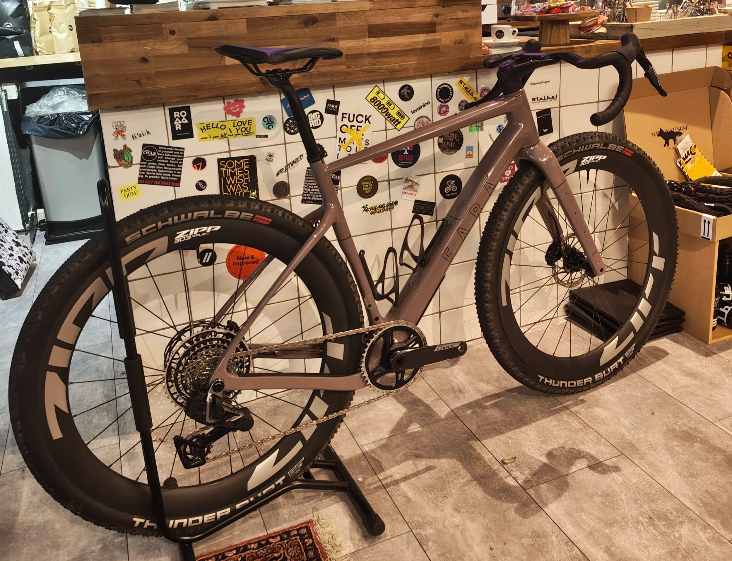 Ein schwarzes Mountainbike mit dicken Reifen, das auf einem Fahrradständer steht.