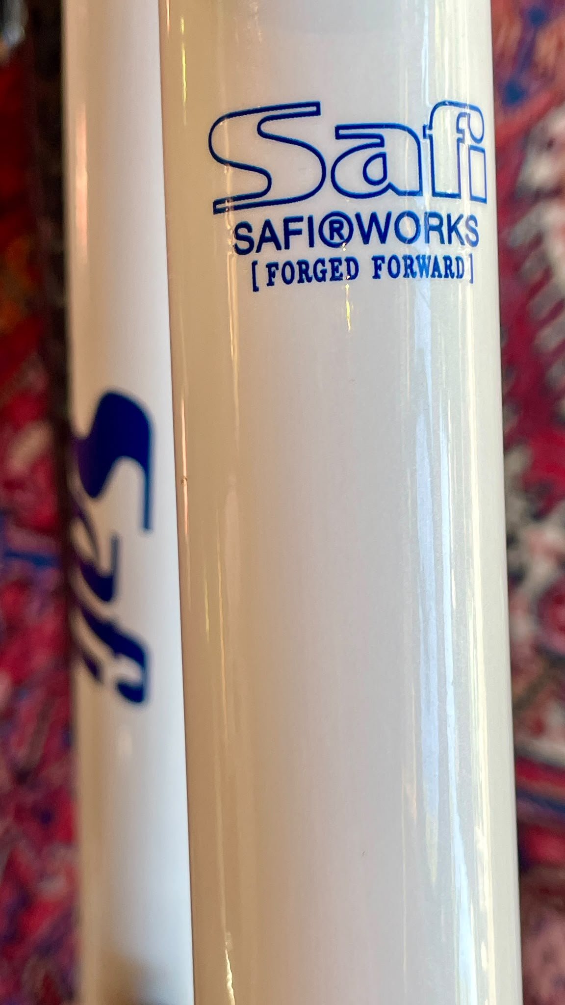 Nahaufnahme einer weißen Flasche mit dem blauen Safi-Logo und der Beschreibung "Safiworx [Forged Forward]" darauf.
