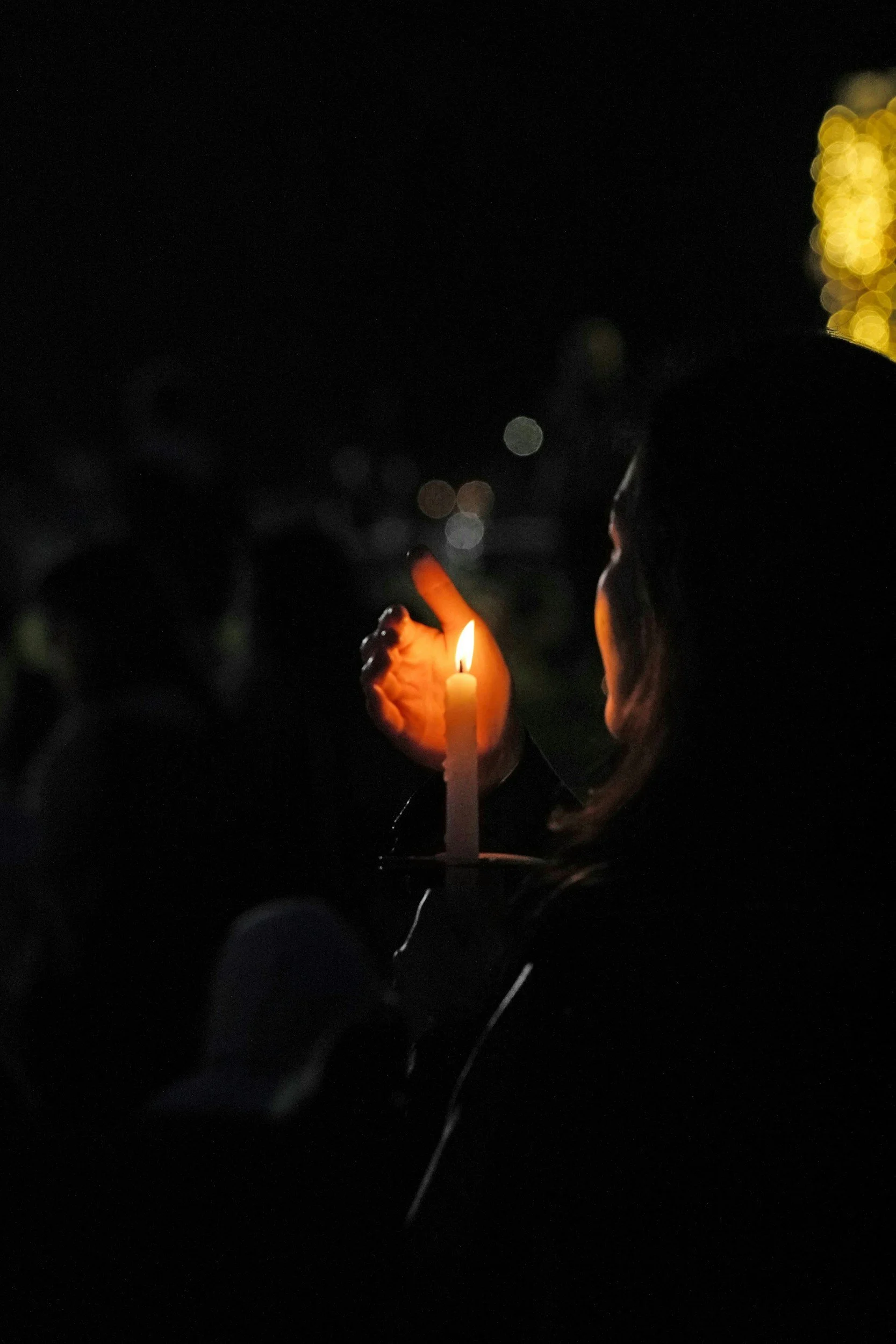 A woman holding a candle before her face