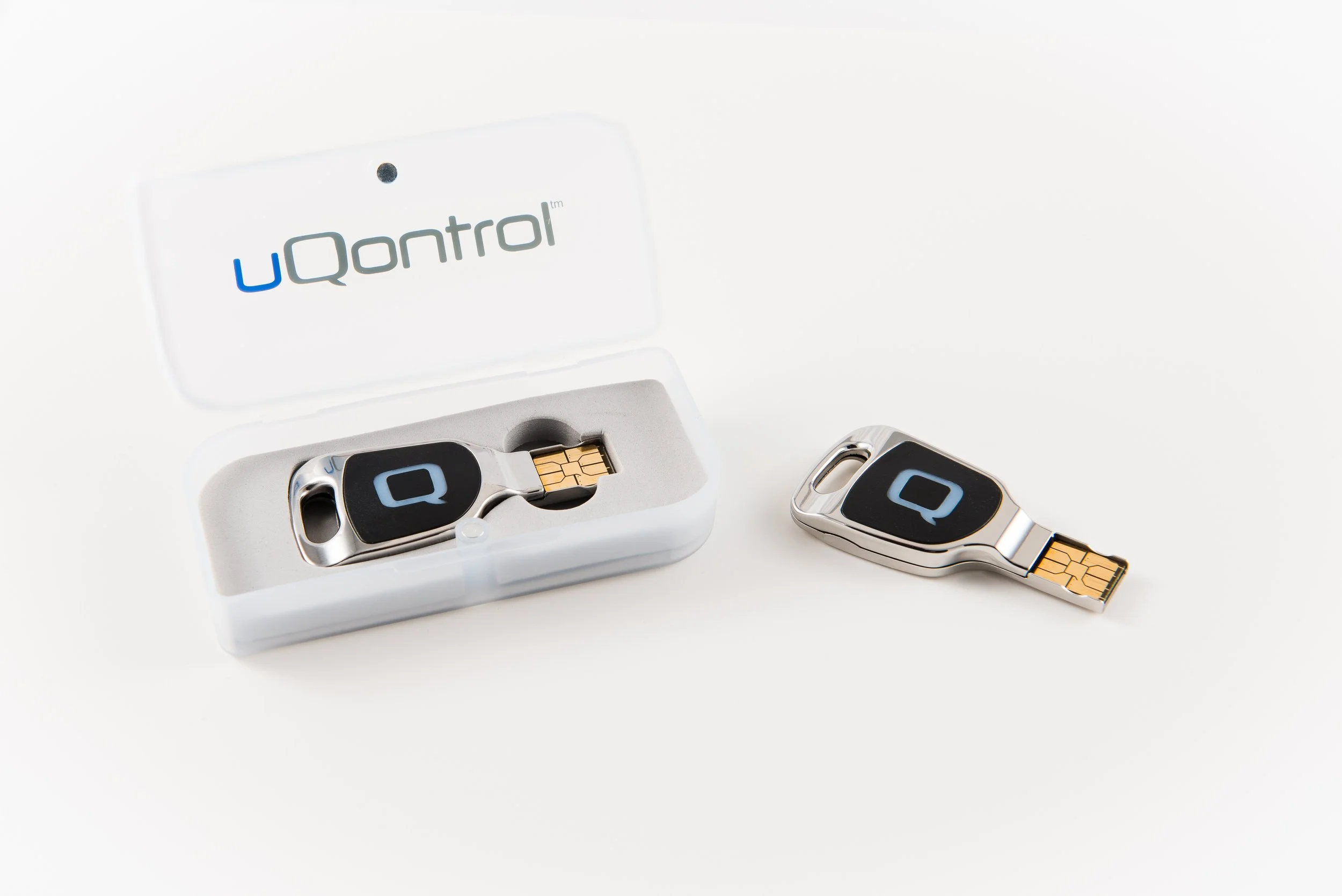 A pair of uQontrol USB security keys with one placed outside a white case, and the other inside the case, on a white background.
