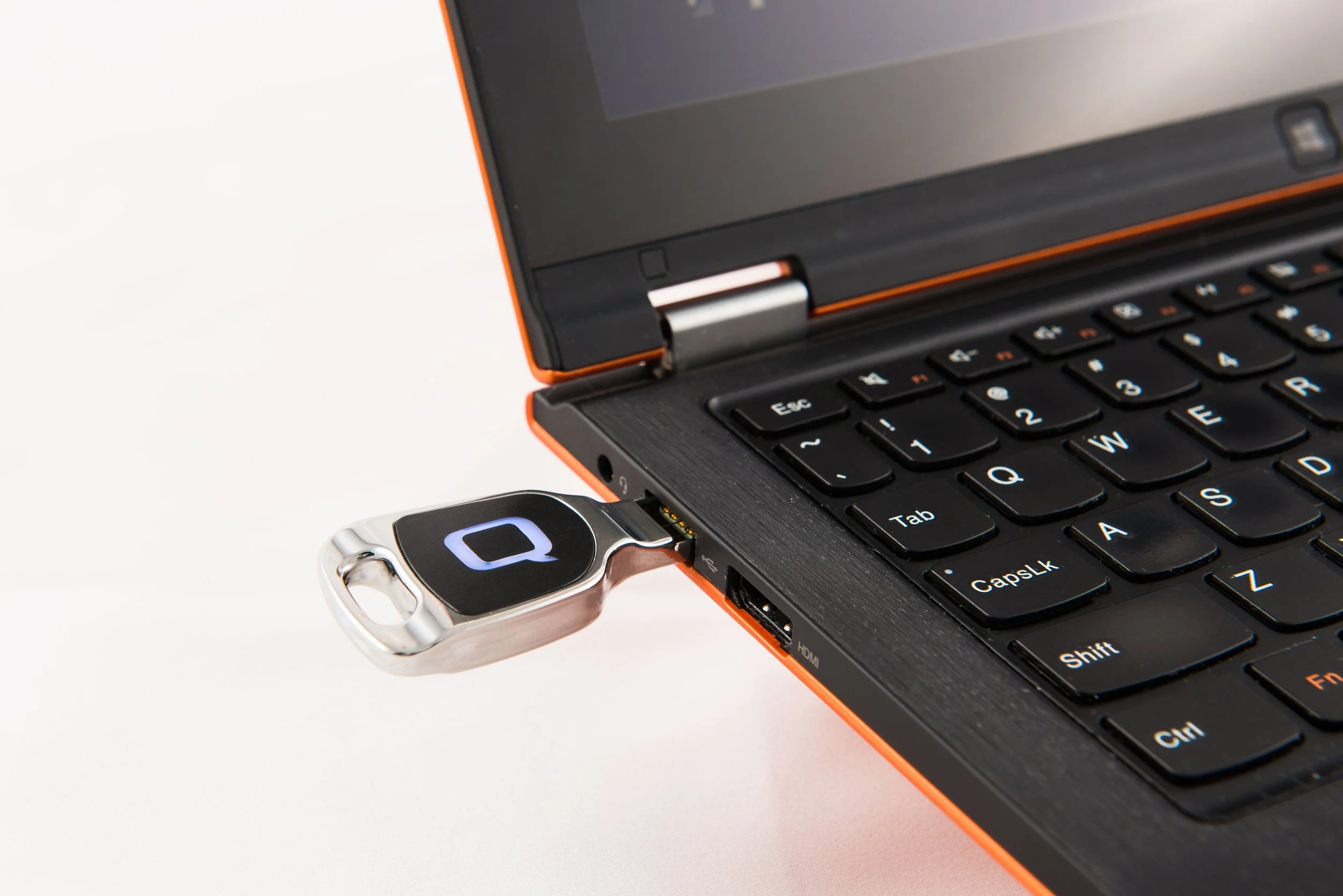 A laptop computer connected to a flash drive with a digital logo on it.