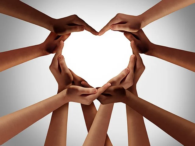 Multiple hands forming a heart shape against a plain background.