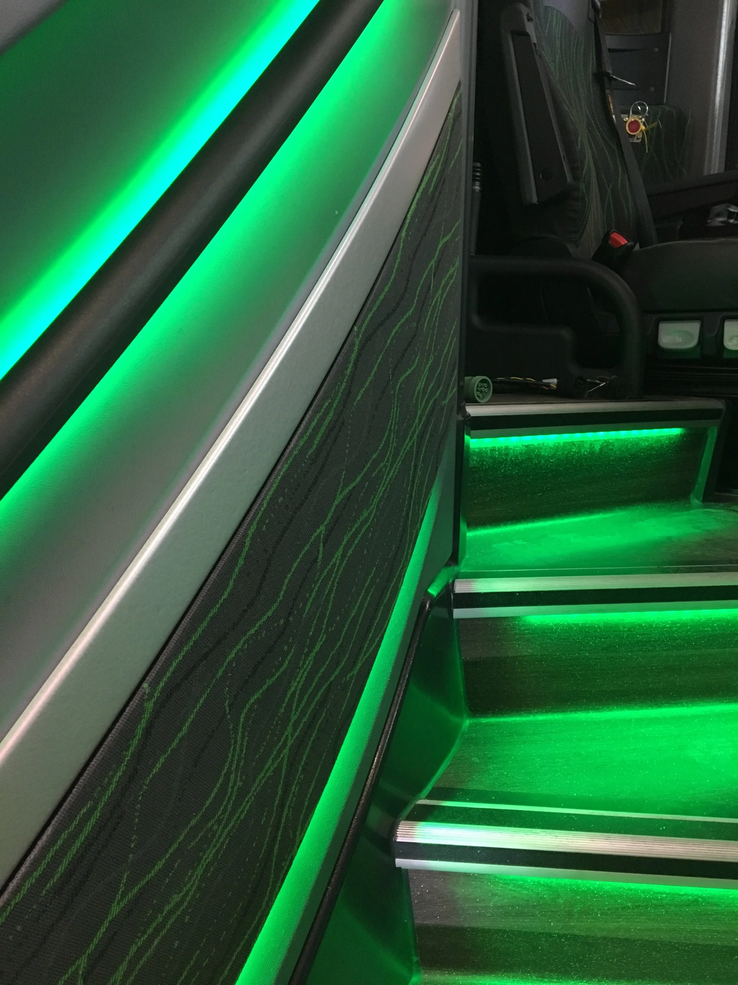 Close-up of a gaming or entertainment station with green LED lighting accents and a black textured surface.
