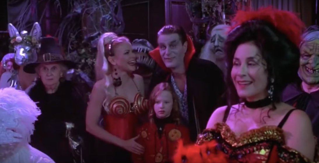Halloween party scene from the movie "Hocus Pocus" of Dani standing in between her parents who are dressed up as Madonna and a vampire.