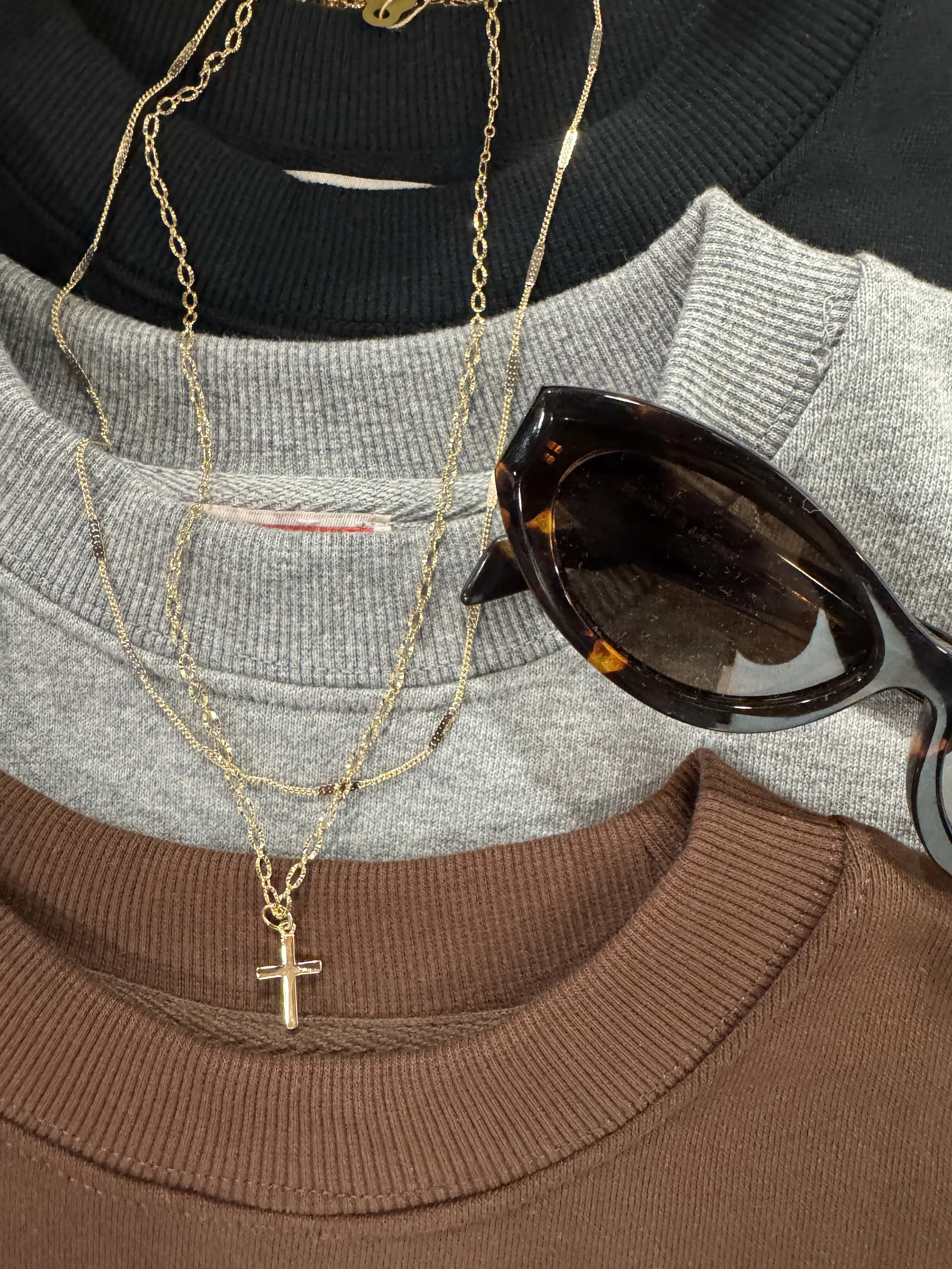 Fall wardrobe staples in earth tones, including a cozy knit sweater, outerwear, and ankle boots