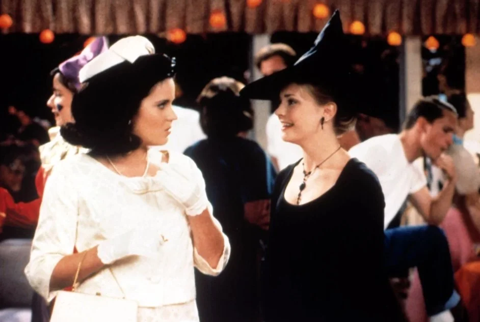 Halloween party scene from the tv show "Sabrina the Teenage Witch" with the character Libby dressed up as Jackie O and Sabrina as a witch.