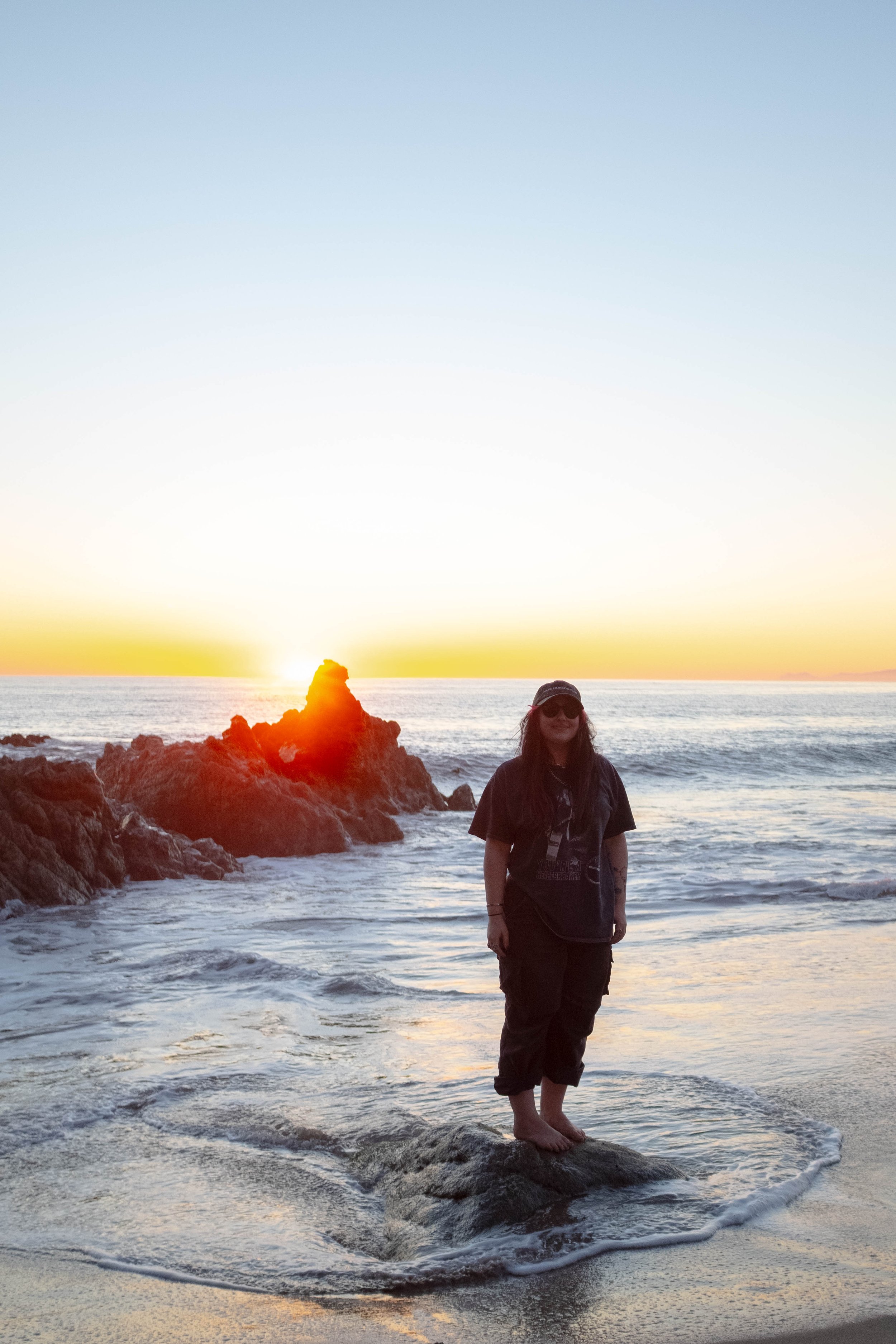 Woman enjoying the sunset and the ocean in Malibu, California