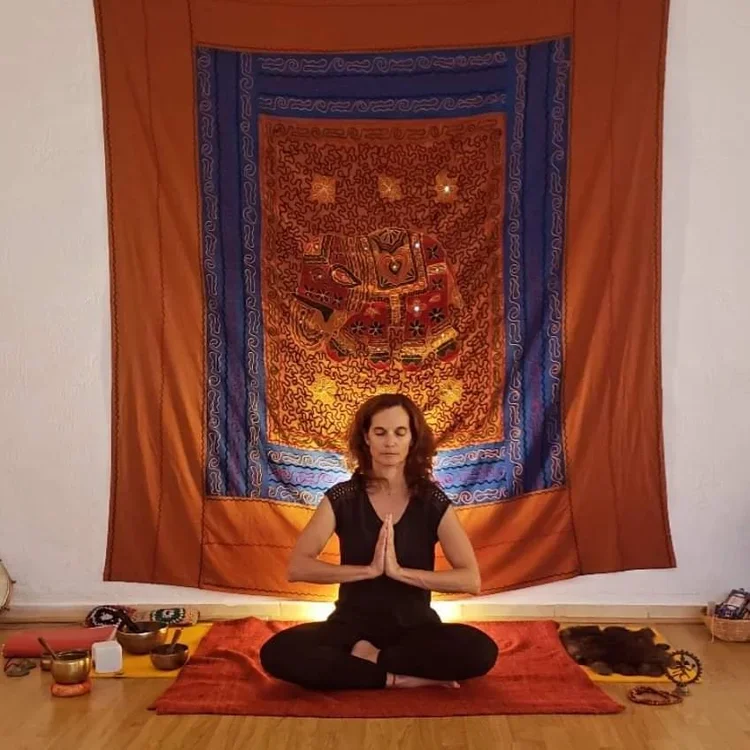 Sophie assise en position de yogi les mains devant le cœur 