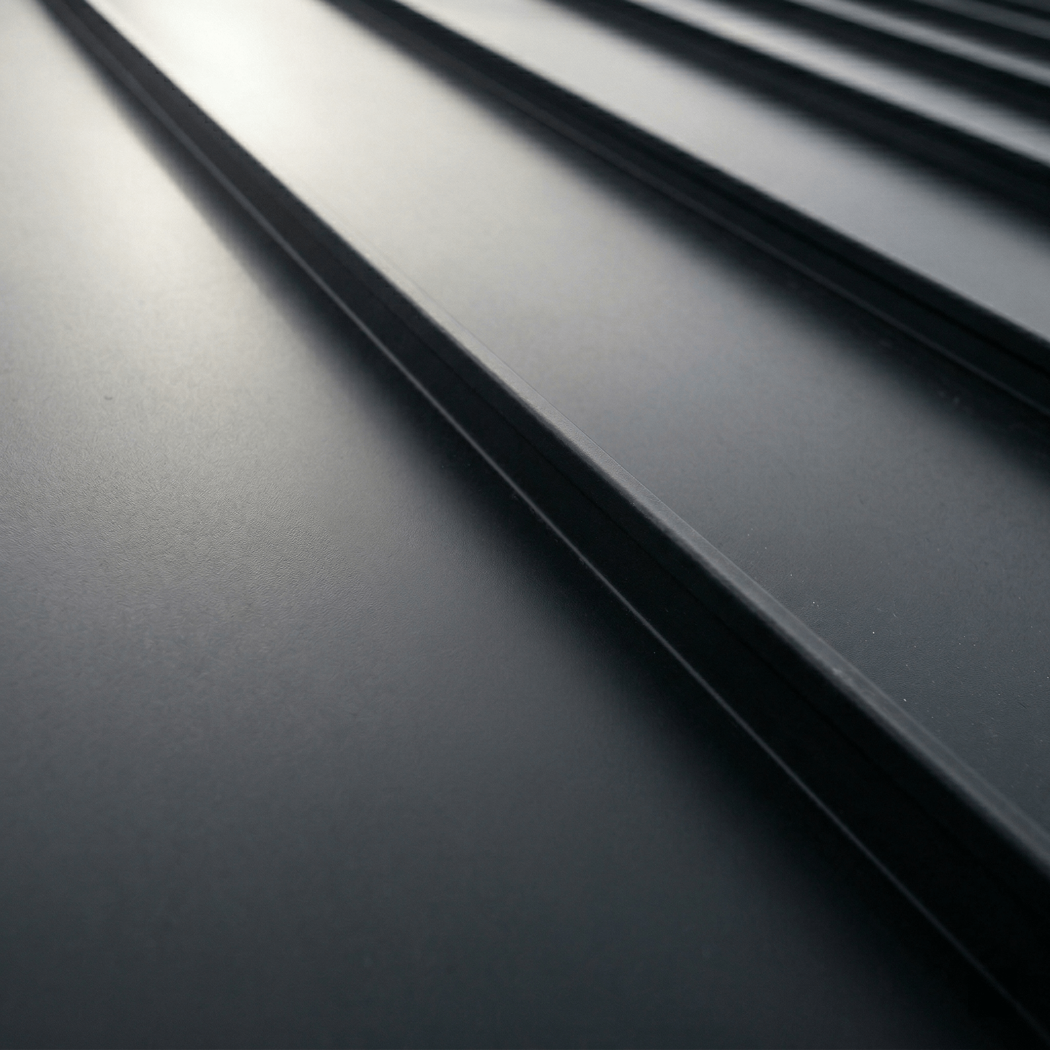 Standing seam metal roof panels close-up showing raised interlocking seams and smooth finish
