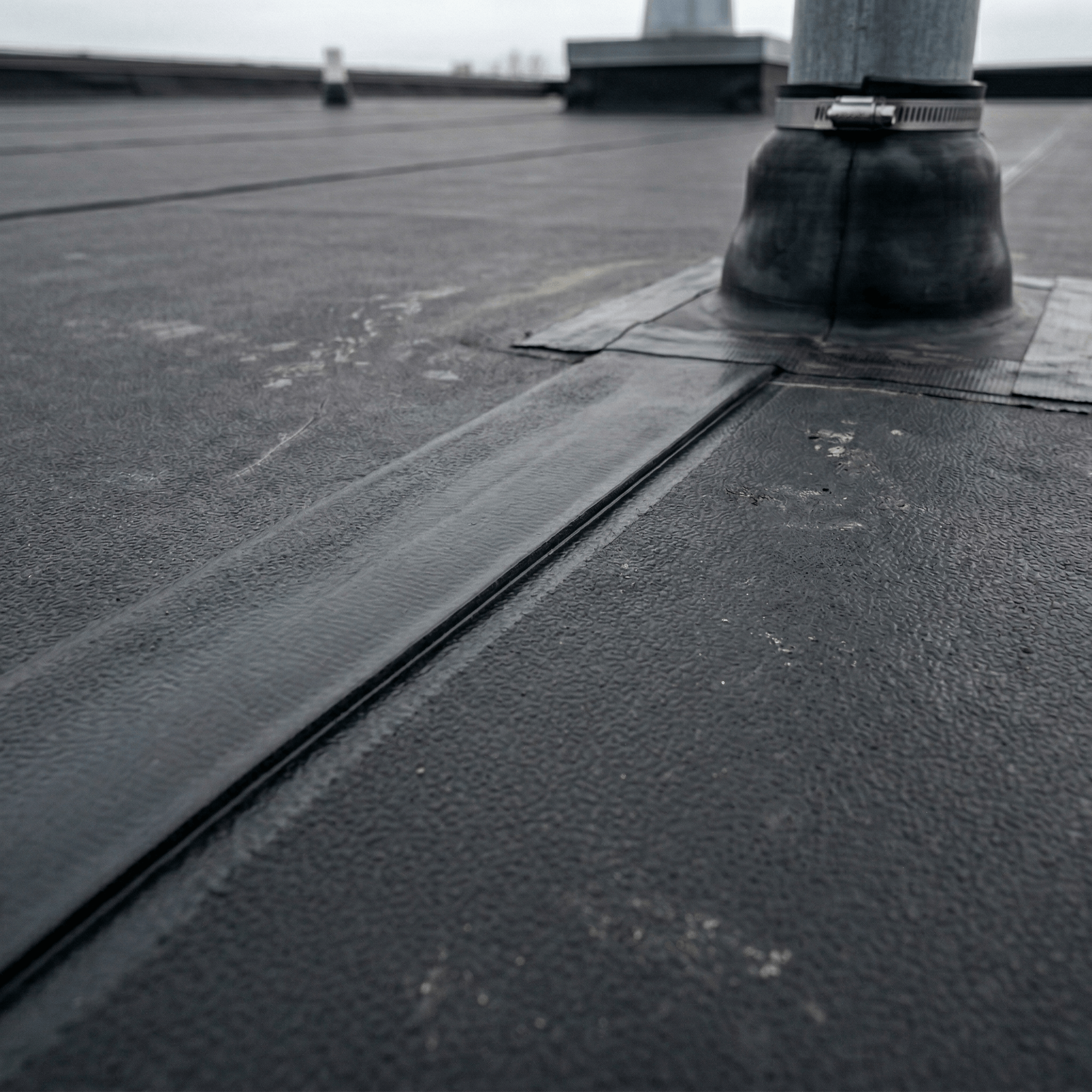 EPDM rubber roofing membrane close-up showing seam detail and pipe penetration flashing