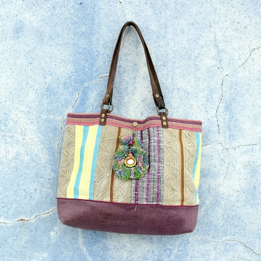 Aso Oke tote with different global textiles on blue wall