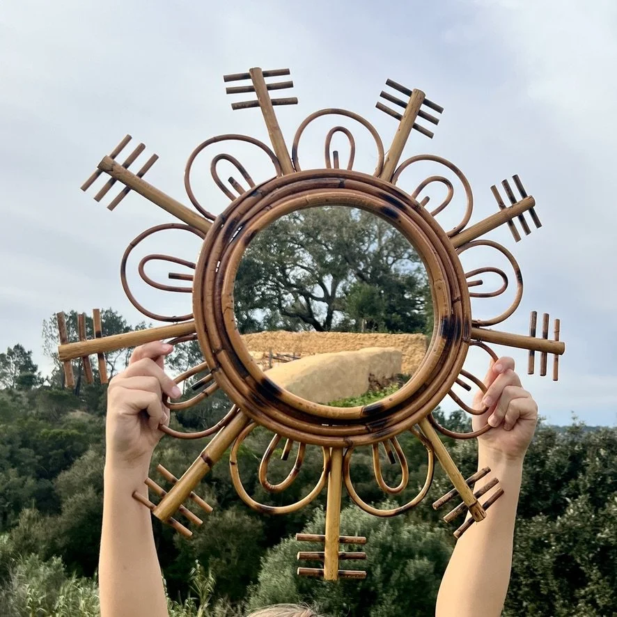 Vintage rattan sun mirror held up