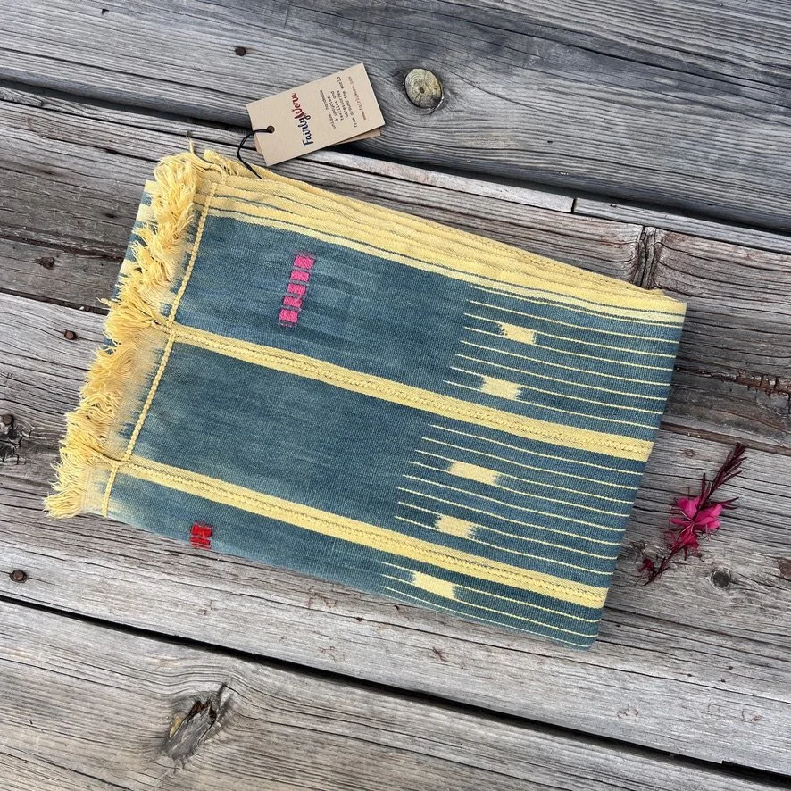 Baoulé blanket petrol yellow folded on wood