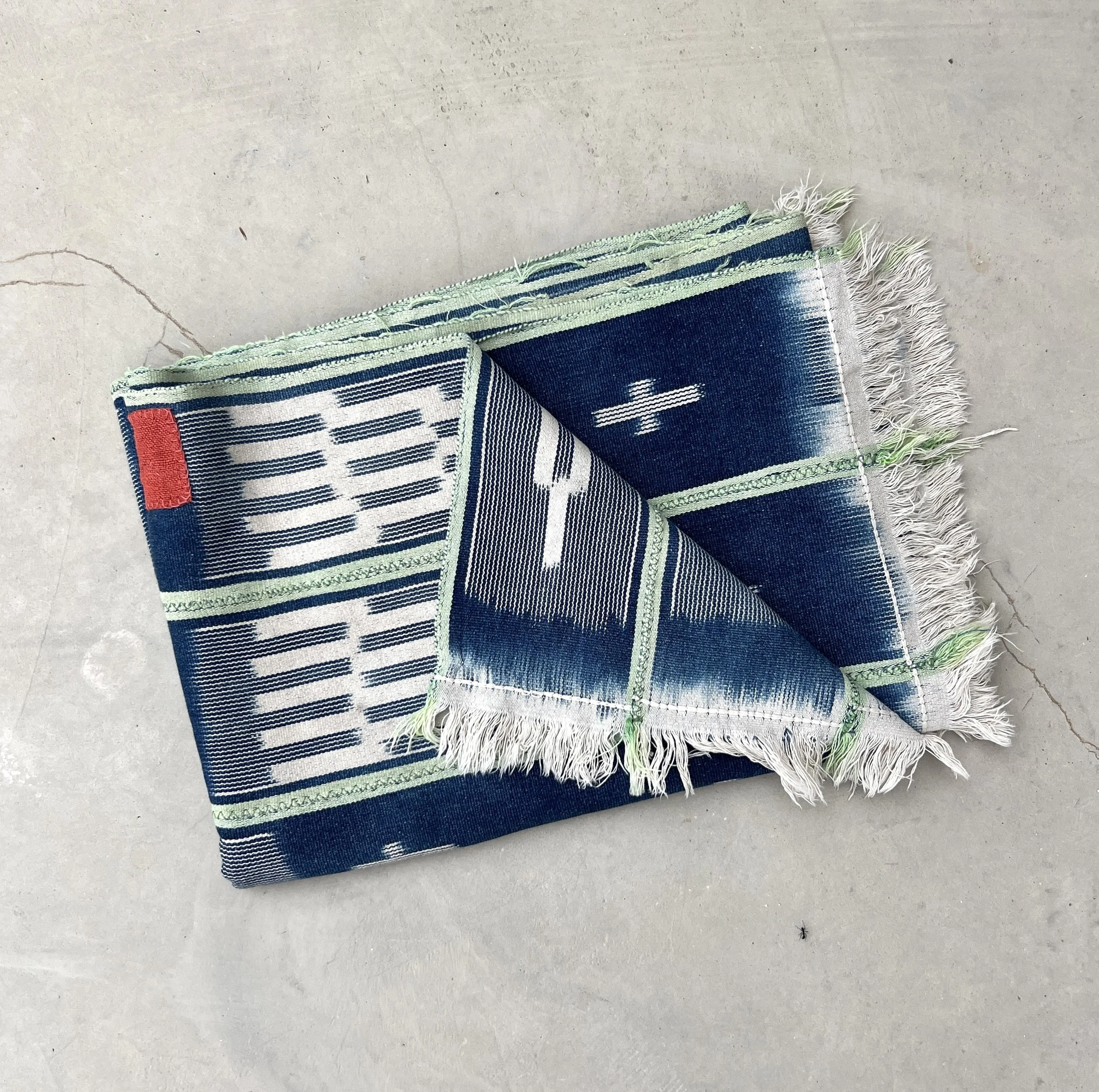 Baoulé blanket green stripes visibly mended folded