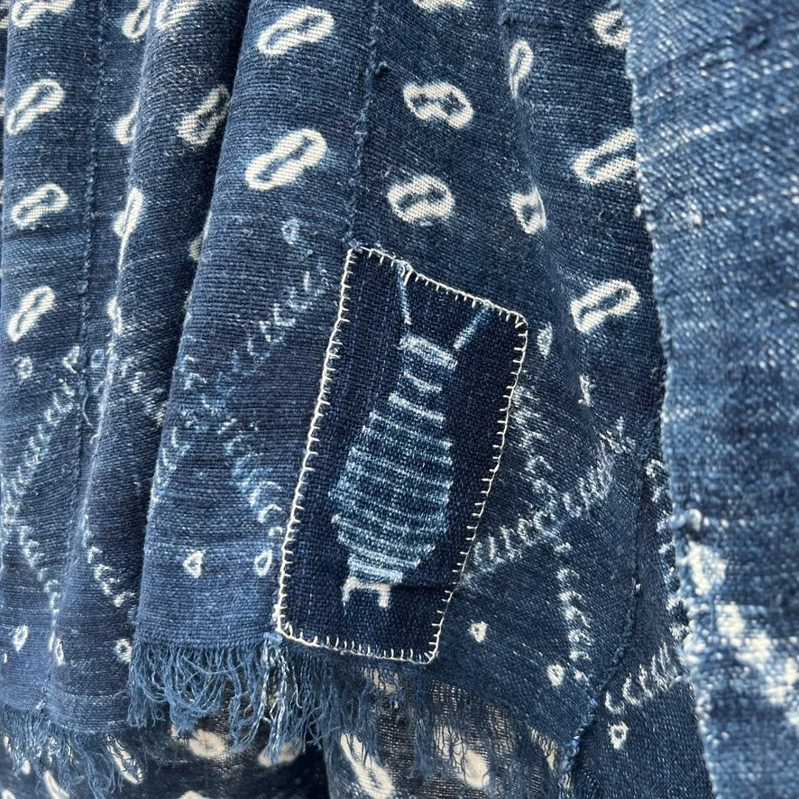 Indigo cloth cowrie shell visibly mended closeup 4