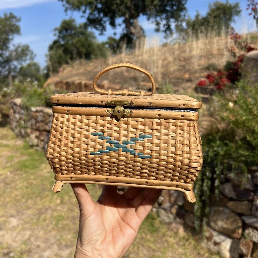 small vintage rattan sewing basket with sewing accessories nature background