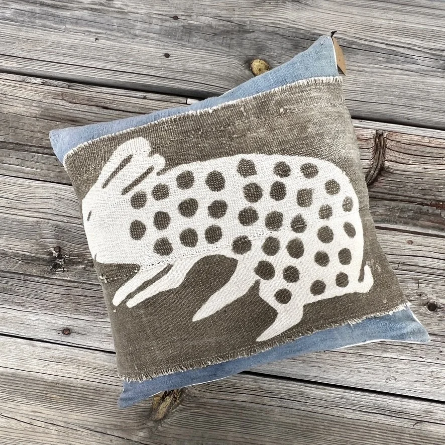 Mali mud cloth cushion cover with bunny motif on wood