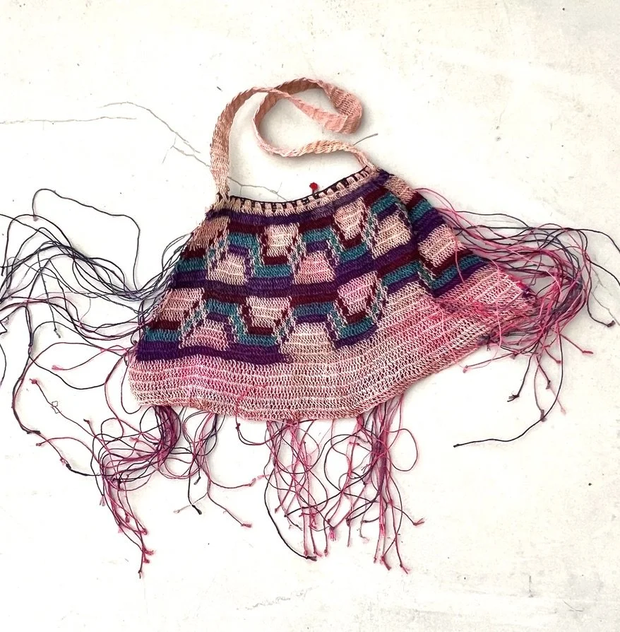 Pink Madang Bilum bag with fringe lying flat backside