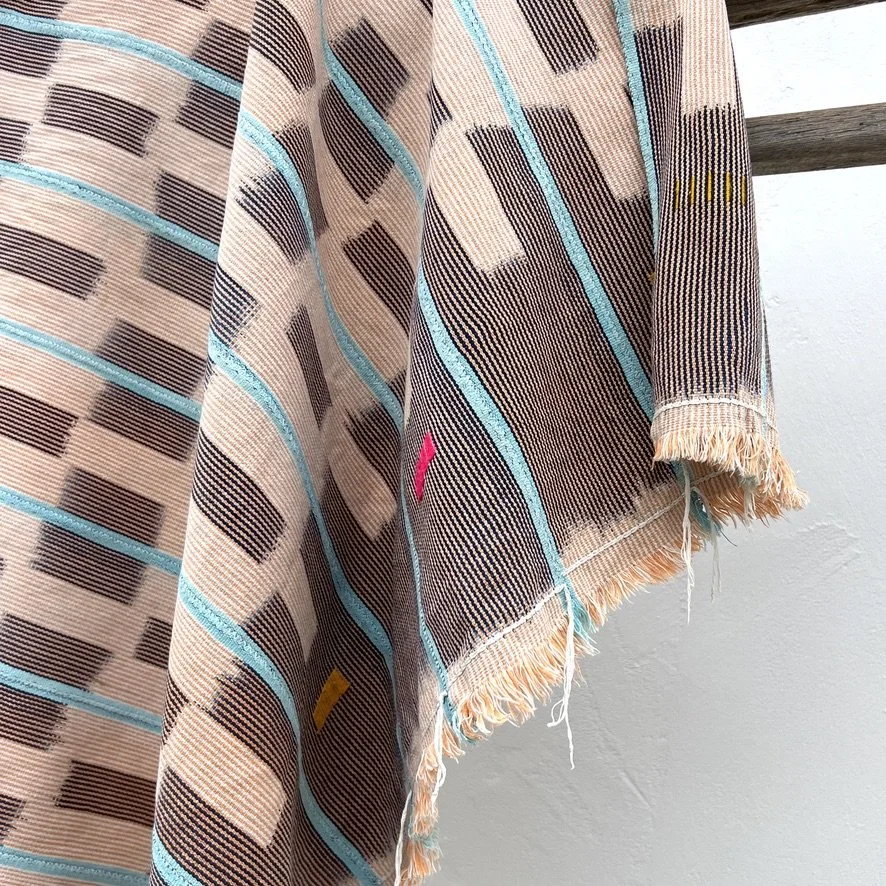 Baoulé blanket aqua stripes on salmon folded closeup