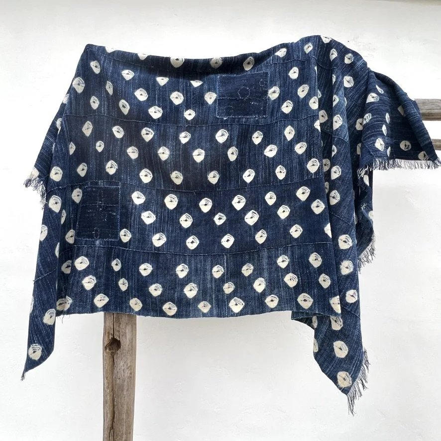 Indigo cloth dark blue cowrie shells visibly mended on stand