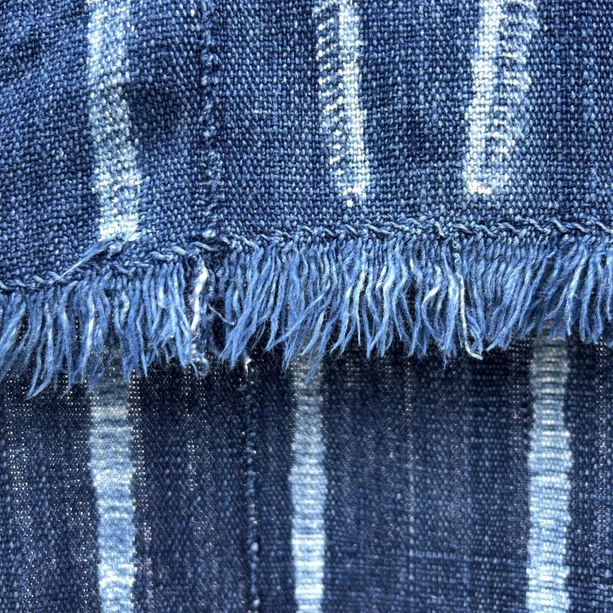 Vintage indigo cloth Mali resist-dyed dots and stripes closeup fringe