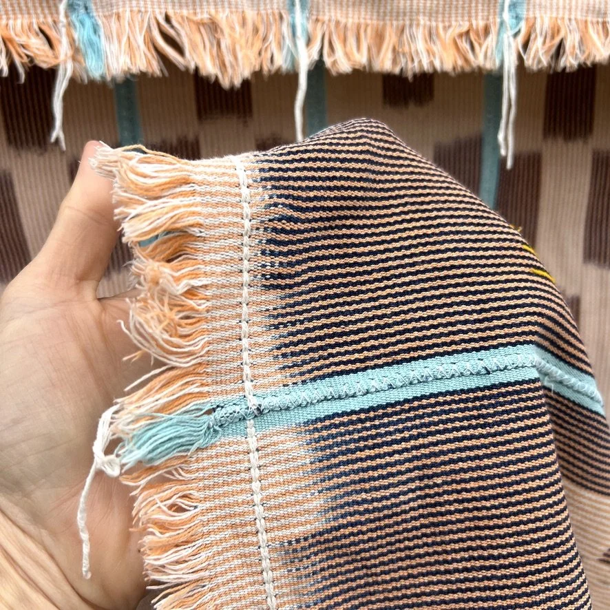 Baoulé blanket aqua stripes on salmon closeup fringe