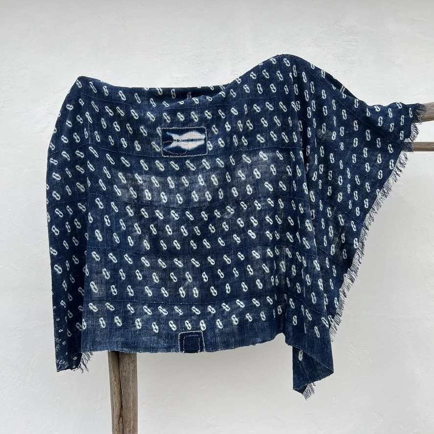 Indigo cloth cowrie shell visibly mended hanging across