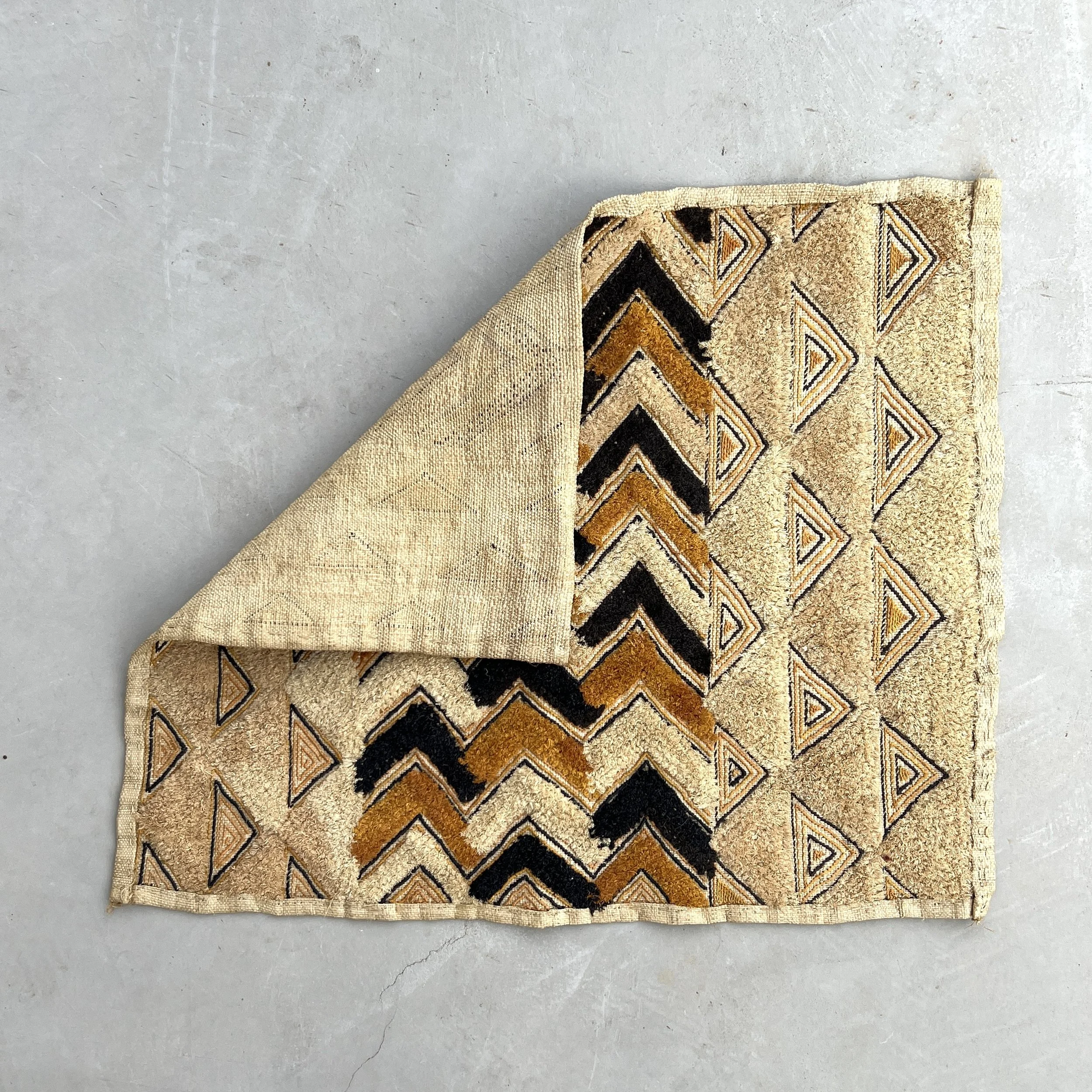 Kuba cloth pile triangles corner folded over