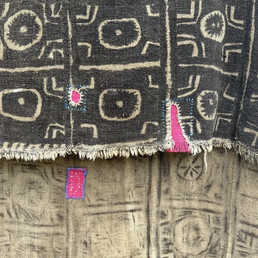 Visibly mended Mali mud cloth closeup front