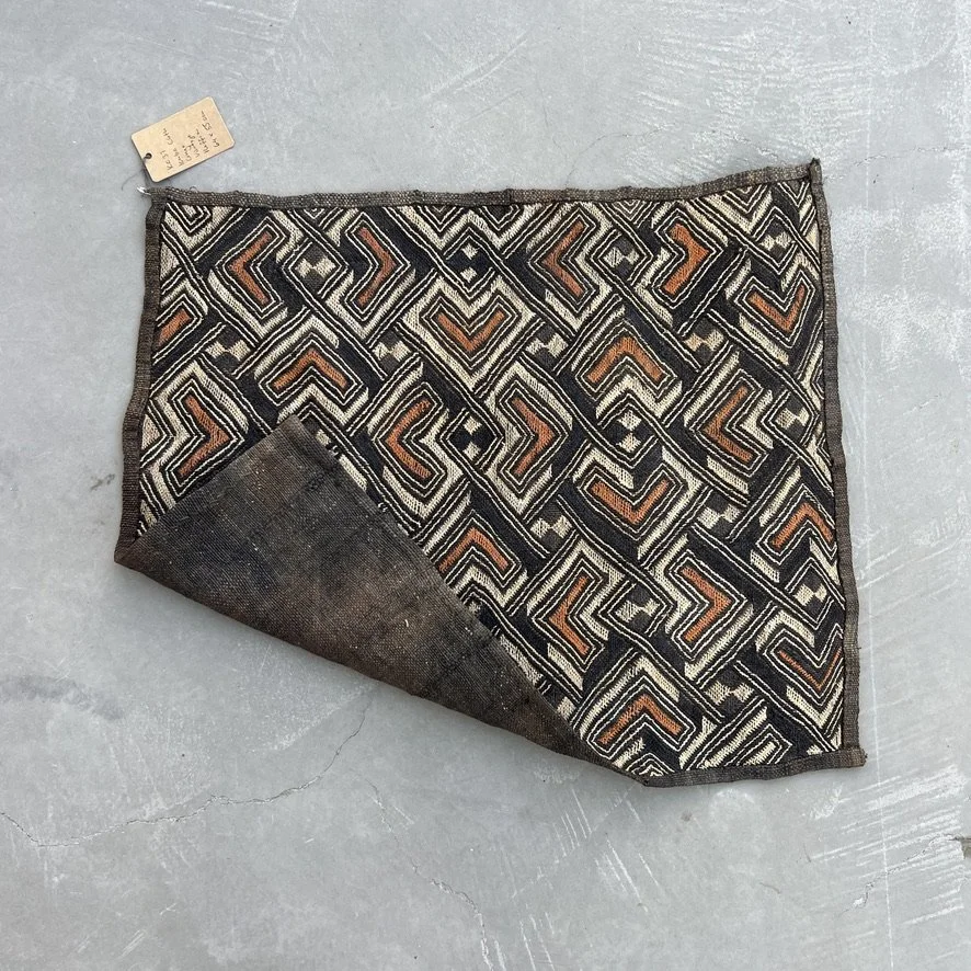Square Kuba cloth from Congo with heart pattern in black, brown and beige with corner folded over