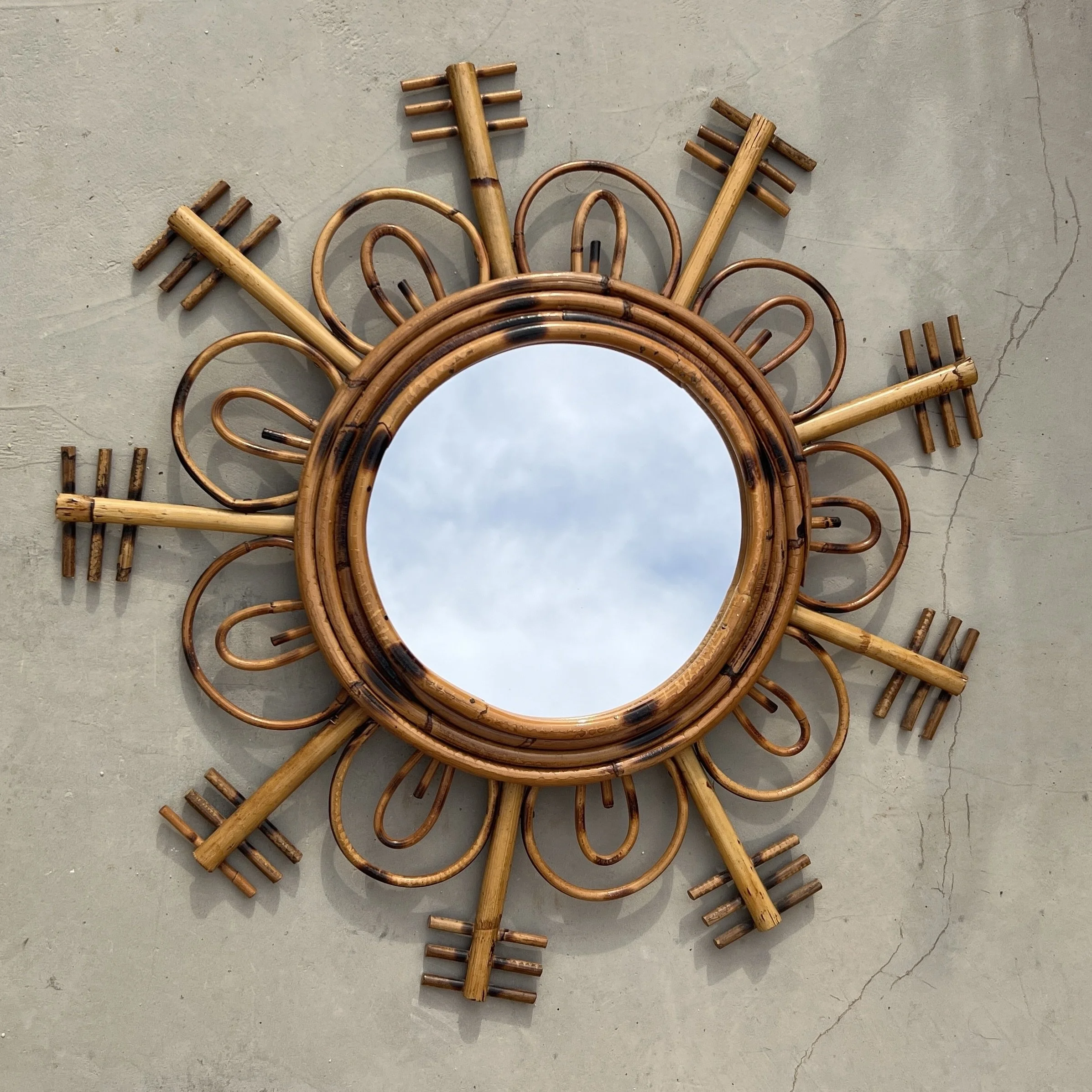 Vintage rattan sun mirror on floor
