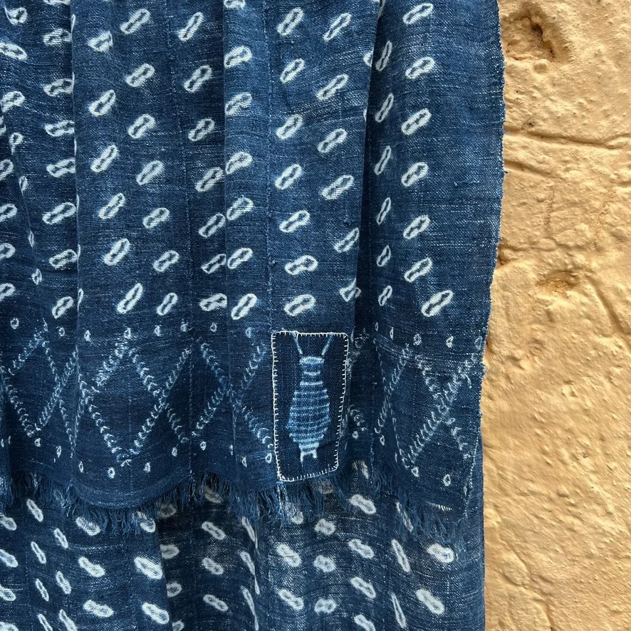 Indigo cloth cowrie shell visibly mended  closeup 1