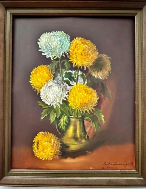 Painting of a bouquet of chrysanthemums in a brass pitcher, with yellow, white, and light green flowers, on a dark background