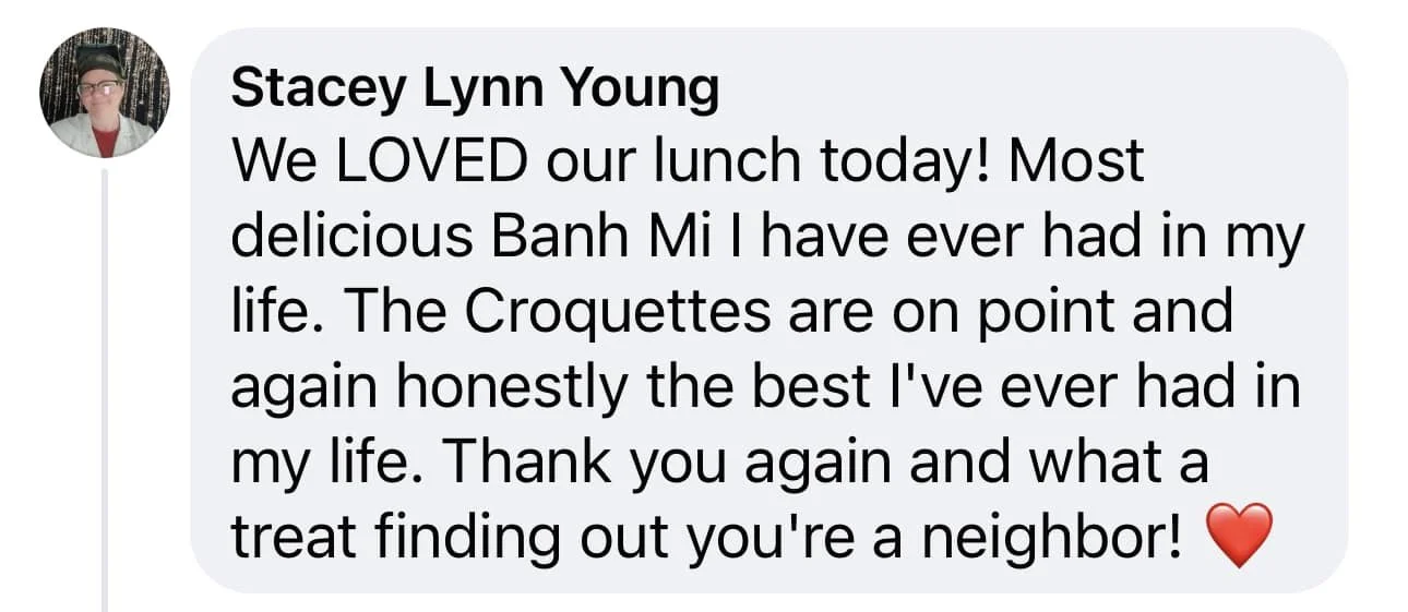 Screenshot of a Facebook comment from Stacey Lynn Young expressing happiness about enjoying a lunch, especially Banh Mi and croquettes, and mentioning the neighbor with a red heart emoji.