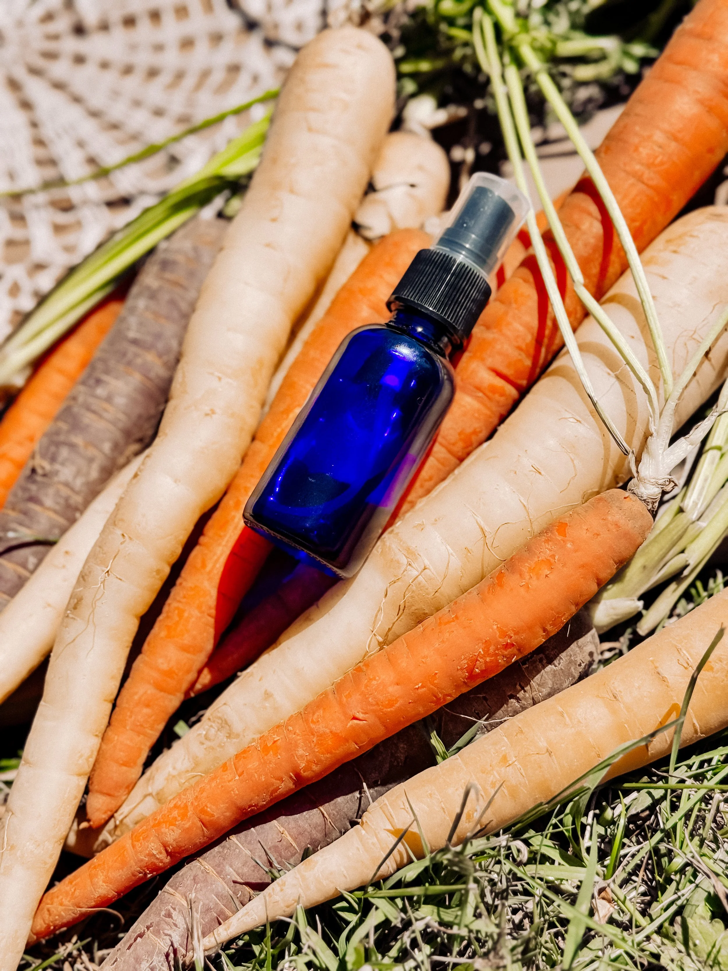 A dark blue jar of yellow skincare with a white lid, lying on its side, in front of a yellow background and a background with sunflower illustrations and the text 'hello sunshine' and 'SunStar Soapery'.