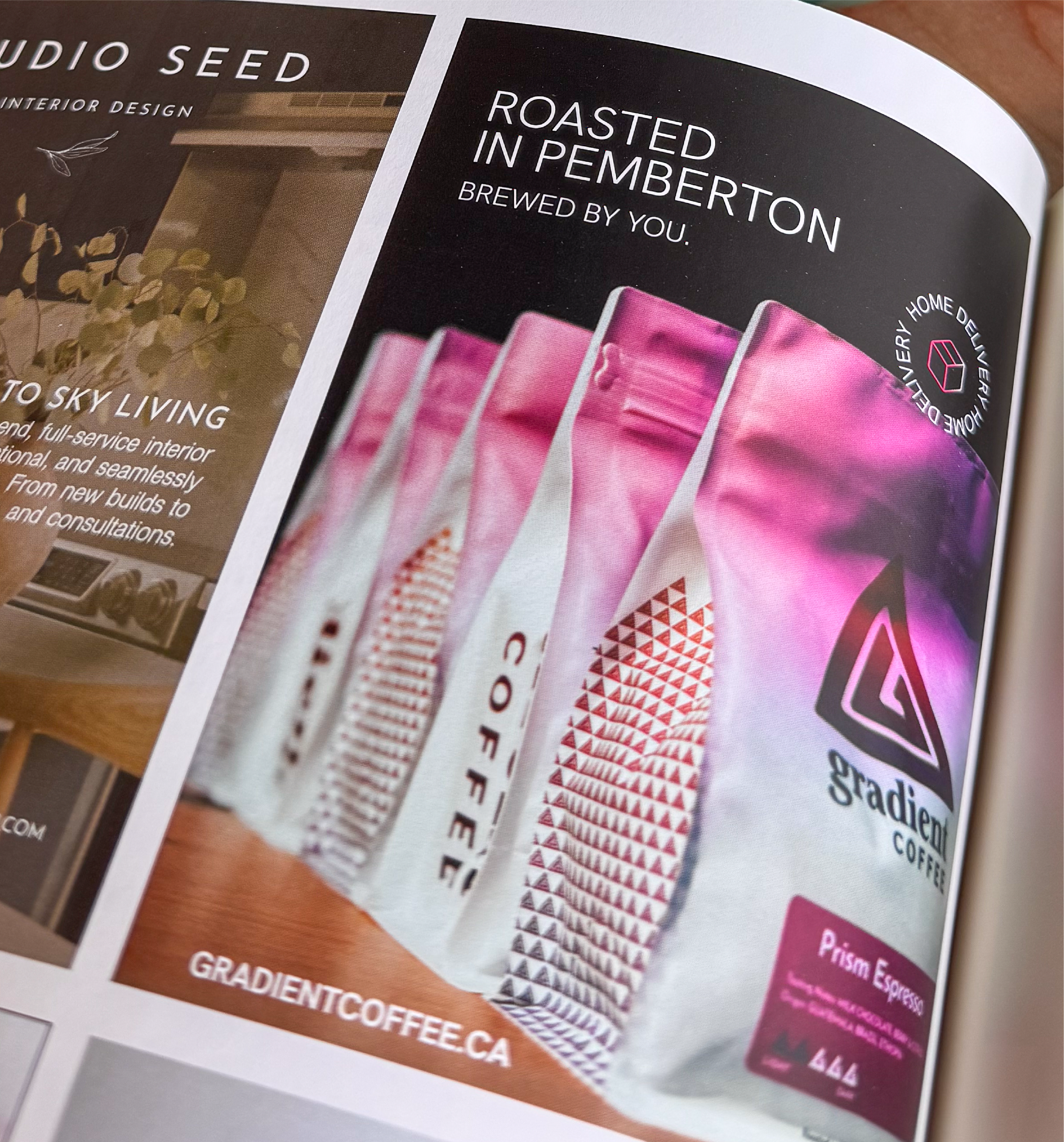 Gradient Coffee ad in a magazine featuring pink coffee bags with “Roasted in Pemberton, brewed by you” text and website link.