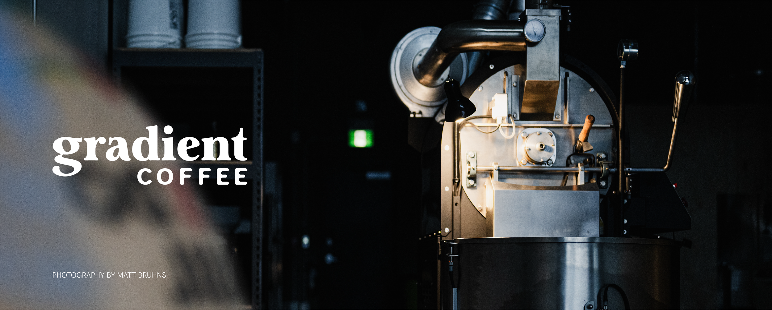 Coffee roaster machine in a dimly lit space with “Gradient Coffee” branding overlay and soft, moody lighting, photographed by Matt Bruhns.