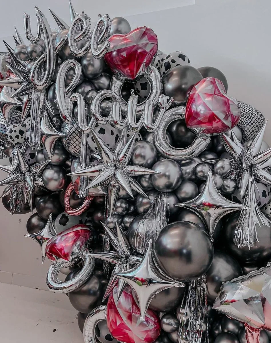 Silver Last Rodeo balloon display with heart and star balloons.