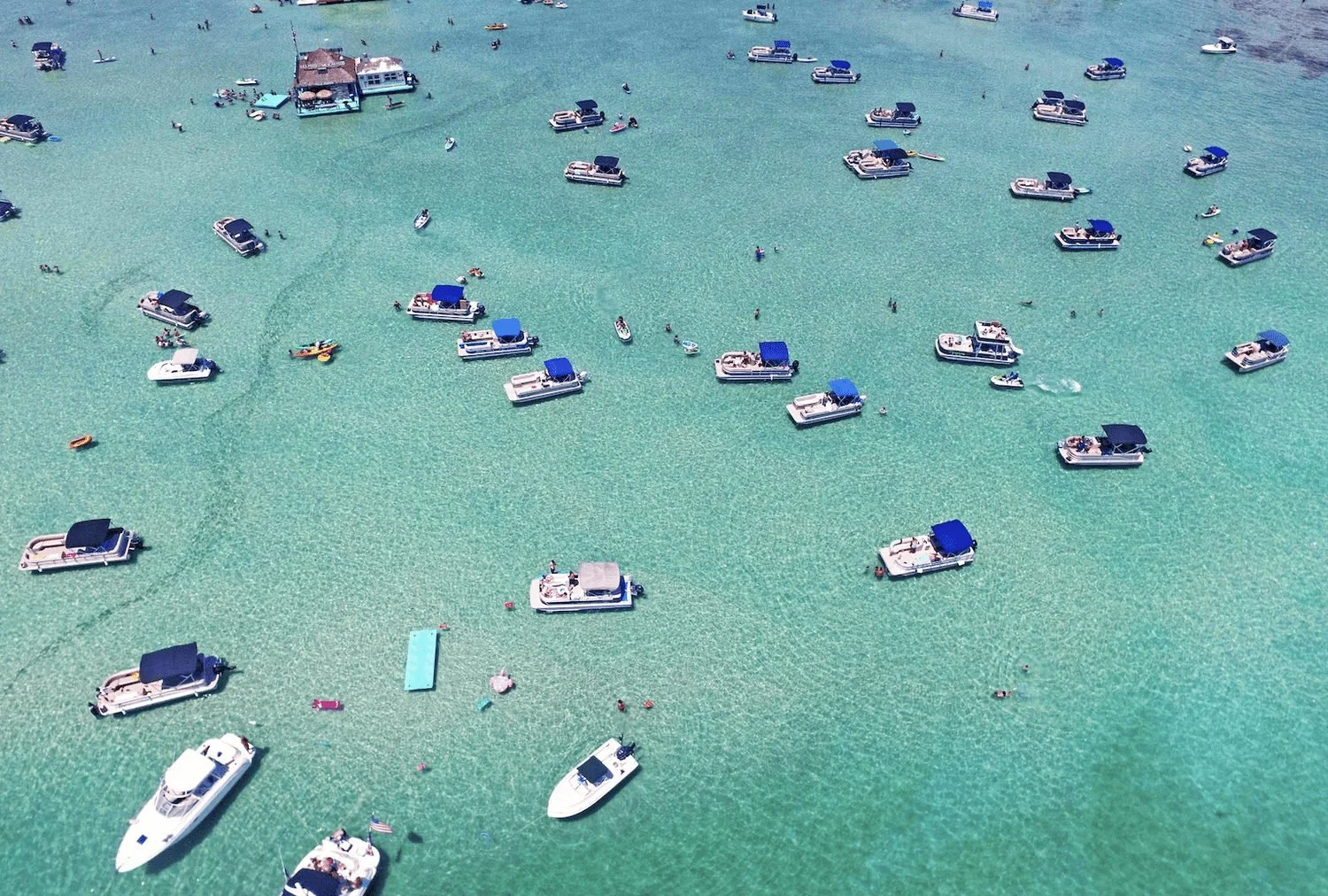 Aerial view of boats anchored in clear turquoise water near Destin.