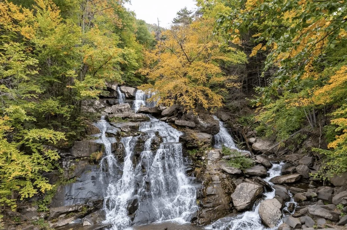 Waterfall cascading over rocks amid autumn foliage in the Catskills.