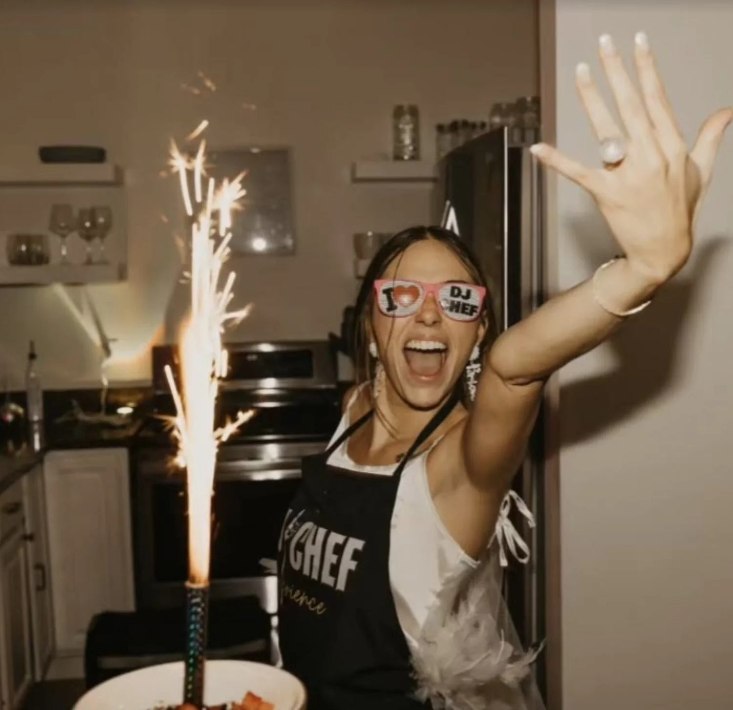 Bride-to-be celebrating beside a sparkling dessert during a private chef dinner.