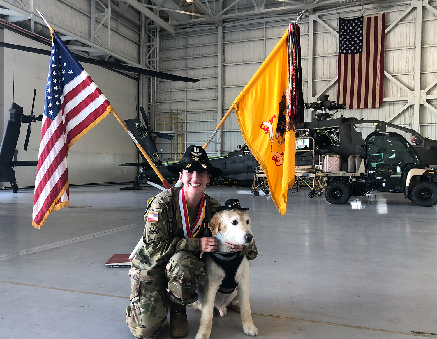 Ashley Ehasz in uniform with dog in front of chopper